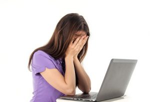 Девушка плачет за ноутбуком